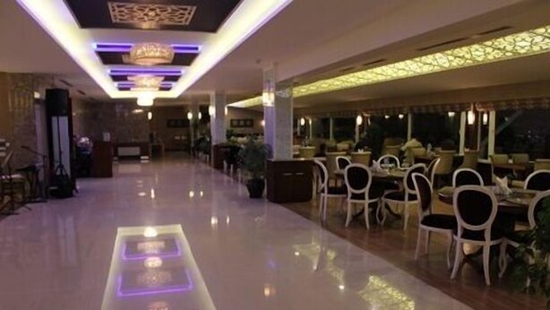 A spacious hotel lobby with a polished floor, modern lighting fixtures, and a long corridor leading to dining areas. - Sivas Buyuk Hotel (Sivas)