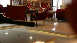 A hotel lobby with a chandelier, red upholstered chairs, a table, and a lamp. - Sivas Buyuk Hotel (Sivas)