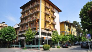Ein mehrstöckiges Hotel mit Balkonen, einem Hotelschild und einem Parkplatzschild in der Nähe.