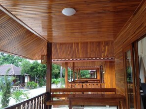 Une terrasse en bois dotée d’une rambarde, de bancs et offrant une vue sur la verdure environnante.