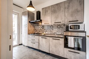 Apartamento, 1 quarto, cozinha | Cozinha privada | Geladeira grande, micro-ondas, fogão, cooktop