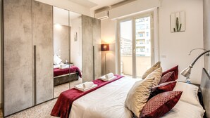 Habitación de hotel moderna con una cama grande, armario, balcón y vistas a la ciudad.