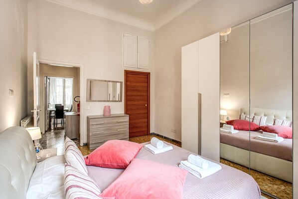 Una habitación de hotel con cama, escritorio, cómoda y un espejo grande.