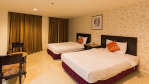 A hotel room with two beds, a chair, a nightstand, and a curtain. - Lotus Hotel KL Sentral (Kuala Lumpur)