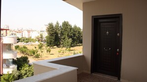 Ein Balkon mit Blick auf eine Stadtlandschaft und Bäume.