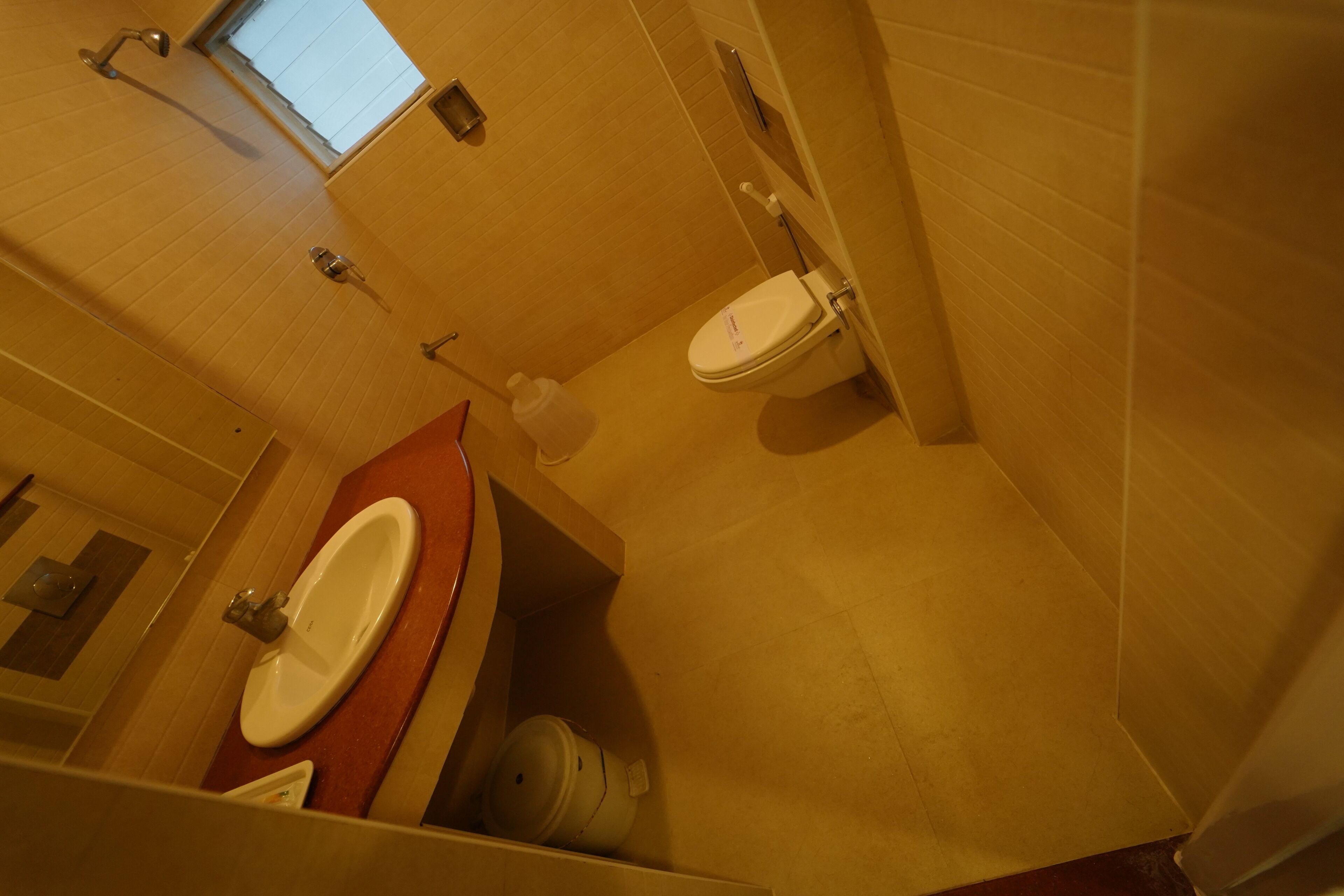 Un baño con lavamanos, inodoro y ventana.