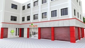 A modern building with a flat roof, multiple windows, and a prominent red and white facade. - Hotel Palmyra Grand Inn (Tirunelveli)