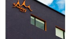 Ein modernes Gebäude mit dunkler Fassade und einem Logo oben.