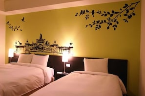 A hotel room with two beds, a decorative wall mural, and two bedside lamps.