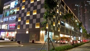 A modern building with a checkered facade, a visible 'DAISO' sign, and a 'P' parking sign. - Cyber Masteri Thao Dien Apartment (Ho Chi Minh City)