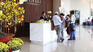 A reception area with a modern design, featuring a reception desk, a large potted plant, and a sign that reads "MASTERI THAODIEN". - Cyber Masteri Thao Dien Apartment (Ho Chi Minh City)