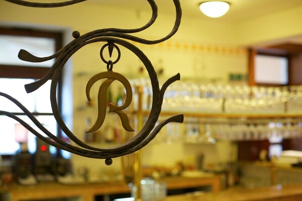 A bar area with a decorative metal sign featuring a large 'R'.