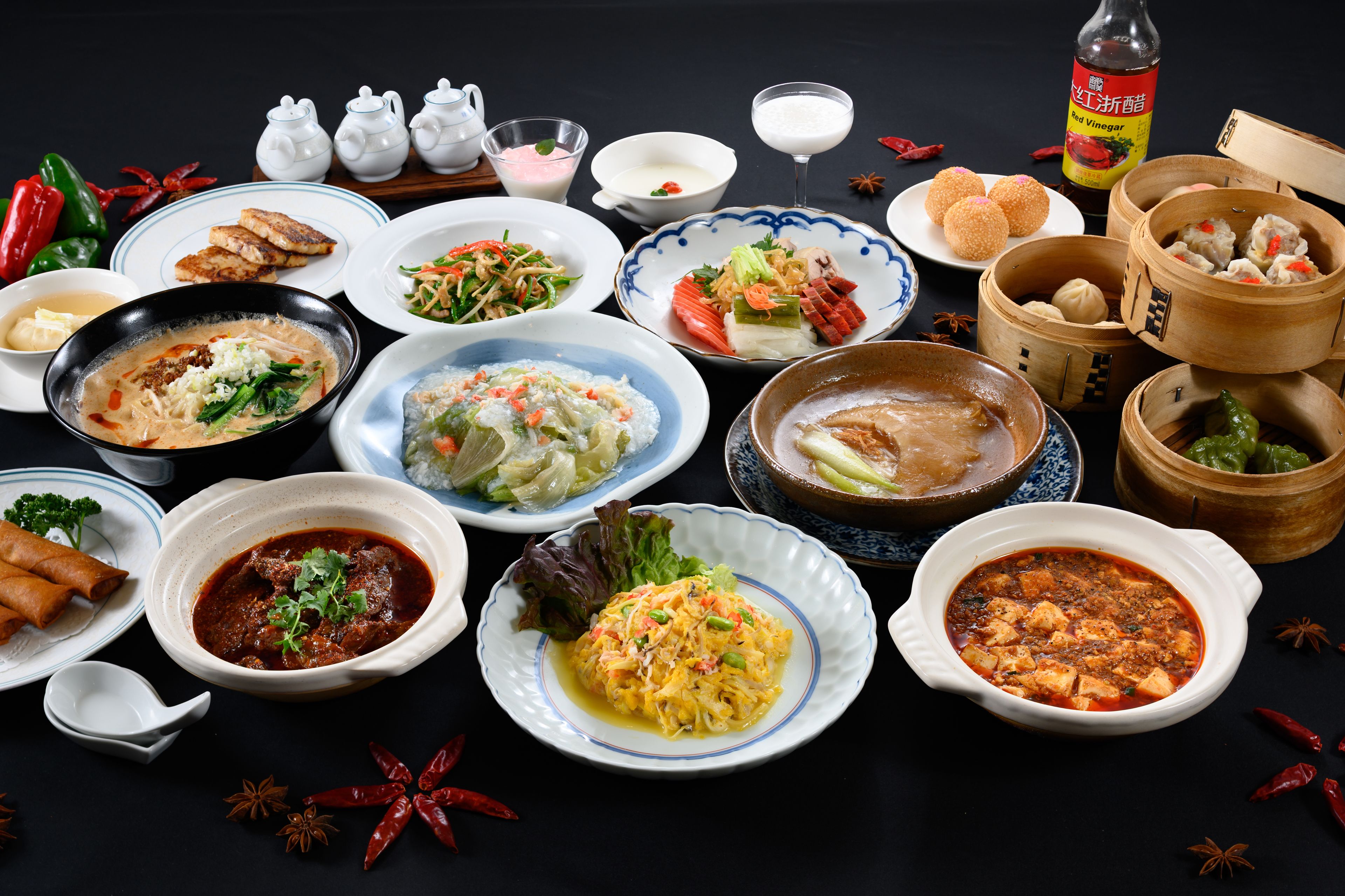 A variety of dishes including dumplings, soup, and stir-fried vegetables.