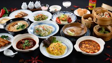 A variety of dishes including dumplings, soup, and stir-fried vegetables.