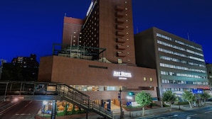A hotel with a prominent Art Hotel sign, a modern building with multiple floors, and a staircase leading to the entrance. - ART HOTEL Morioka (Morioka)