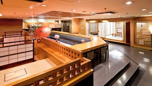 A modern hotel lobby with a reception desk, seating area, and traditional decor elements. - ART HOTEL Morioka (Morioka)