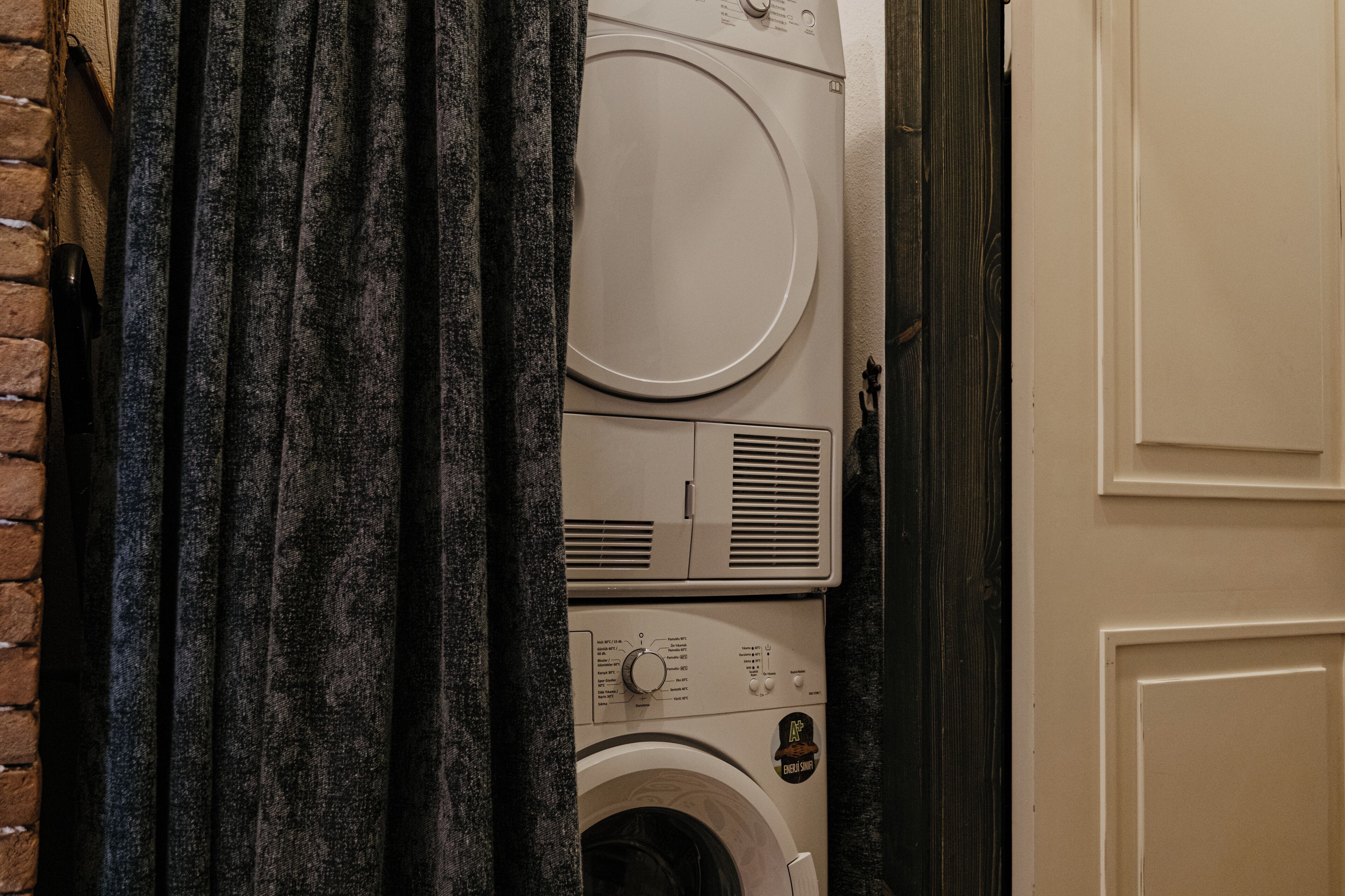 A stacked washer and dryer unit in a laundry room.
