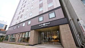A hotel with a modern facade, large windows, and a sign indicating it is a premium establishment. - Smile Hotel PREMIUM SAPPOROSUSUKINO (Sapporo)