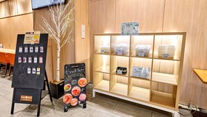 A hotel reception area with a wooden reception desk, a display board with various items, and a shelf with containers. - Smile Hotel PREMIUM SAPPOROSUSUKINO (Sapporo)
