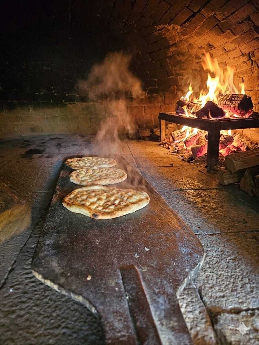 Four flatbreads cooking on a stone surface in a brick oven with a fire in the background.