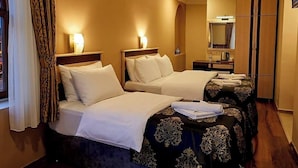 A hotel room with two beds, a mirror, a wardrobe, and a window with curtains. - Nemrut Euphrat Hotel (Kahta)