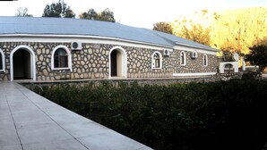 A stone building with arched windows and a flat roof. - Nemrut Euphrat Hotel (Kahta)