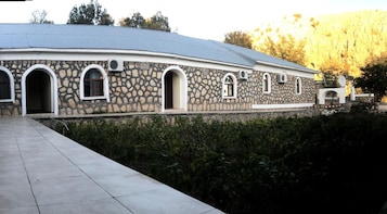 A stone building with arched windows and a flat roof.