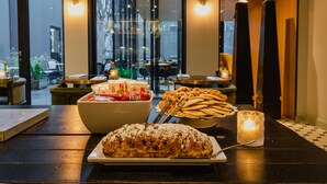 Une table à manger avec une grande miche de pain, un bol de biscuits et une bougie.