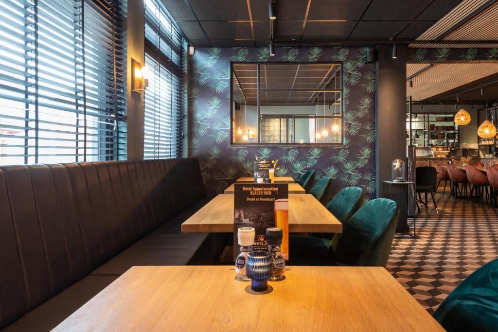 Un interior de restaurante con una mesa de madera, asientos acolchados y piso de tablones.