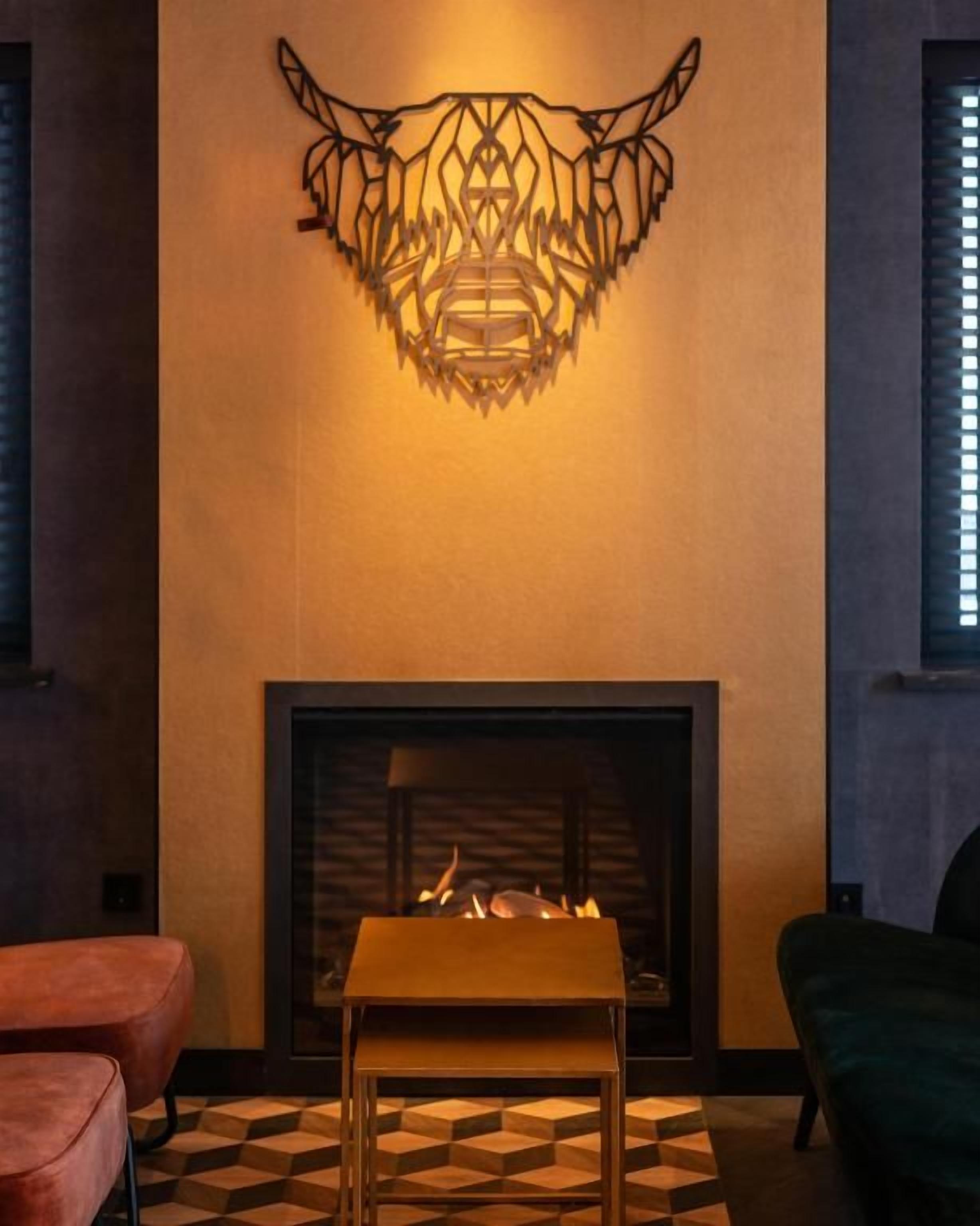 A room with a fireplace, a patterned floor, and a wall-mounted light fixture.