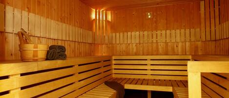 A wooden sauna with benches and a wooden table.