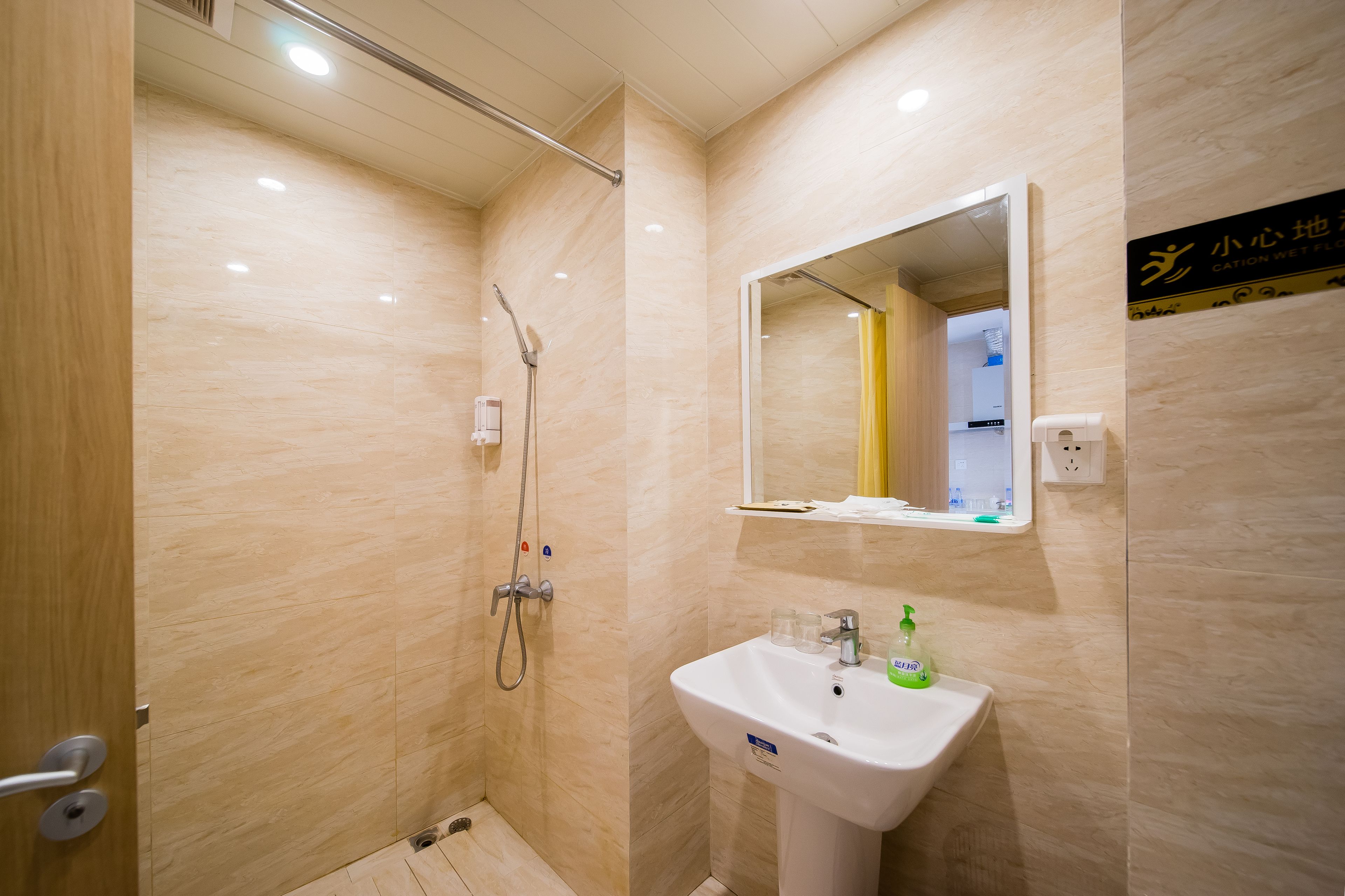 Un bagno moderno con doccia, lavandino e specchio.