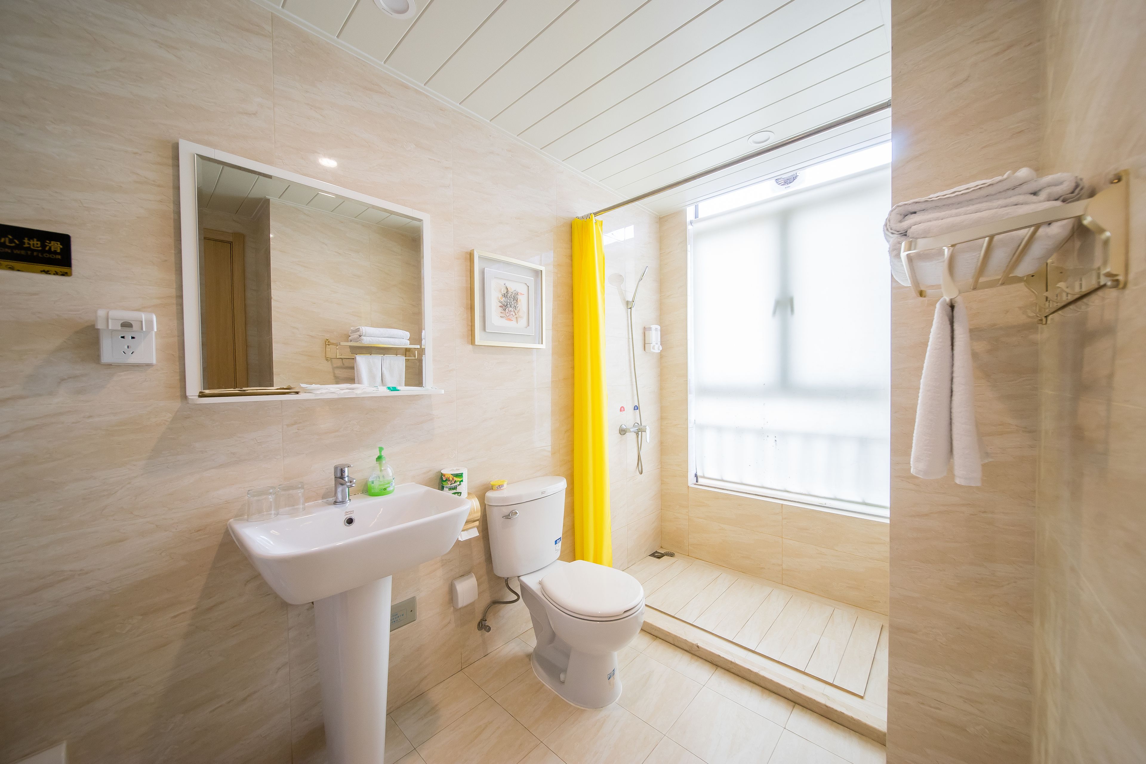 Un baño moderno con lavamanos, inodoro y zona de ducha.