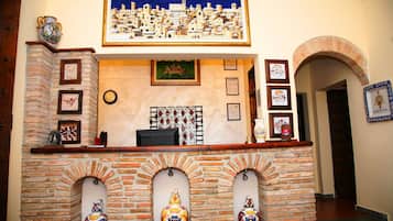 A reception area with a brick fireplace, framed artwork, and decorative vases.