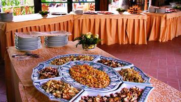 A buffet table with various dishes and plates.
