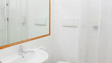 Un baño con lavamanos blanco, inodoro y ducha.