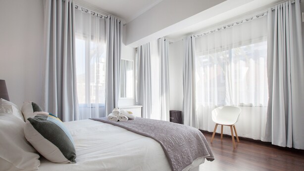Une chambre d’hôtel moderne, dotée d’un grand lit, d’un bureau et d’une chaise.