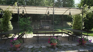 An outdoor patio with a covered seating area, tables, and potted plants. - Agriturismo Case Mori (Rimini)