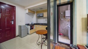 Una cucina compatta con frigorifero, fornello e un piccolo tavolo da pranzo.