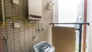 Una stanza con scaldabagno, riscaldatore elettrico e finestra con vista sulla città.