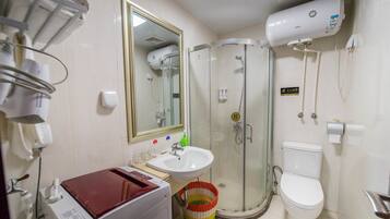 A bathroom with a glass-enclosed shower, a white sink, a toilet, and a mirror.