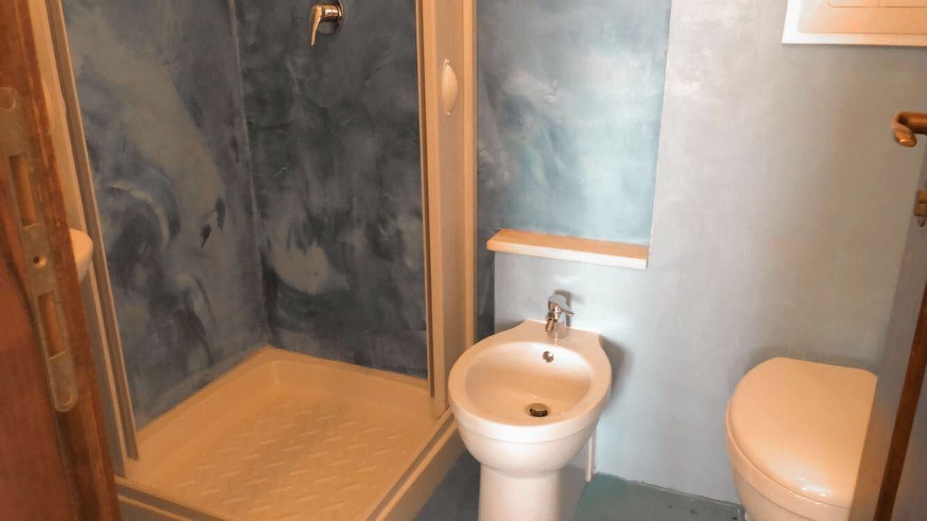 A bathroom with a shower, a sink, and a toilet.