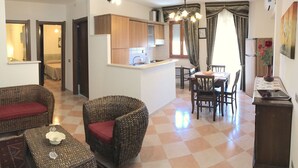 Una sala de estar con mobiliario de mimbre, una cocina y un comedor.