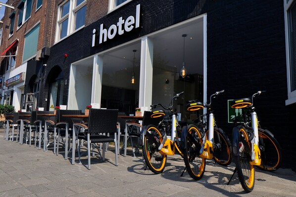 Un hôtel doté d’une terrasse et où plusieurs vélos sont garés à l’extérieur.