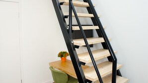 A modern staircase with wooden steps and black metal railings. - I Hotel (Amsterdam)