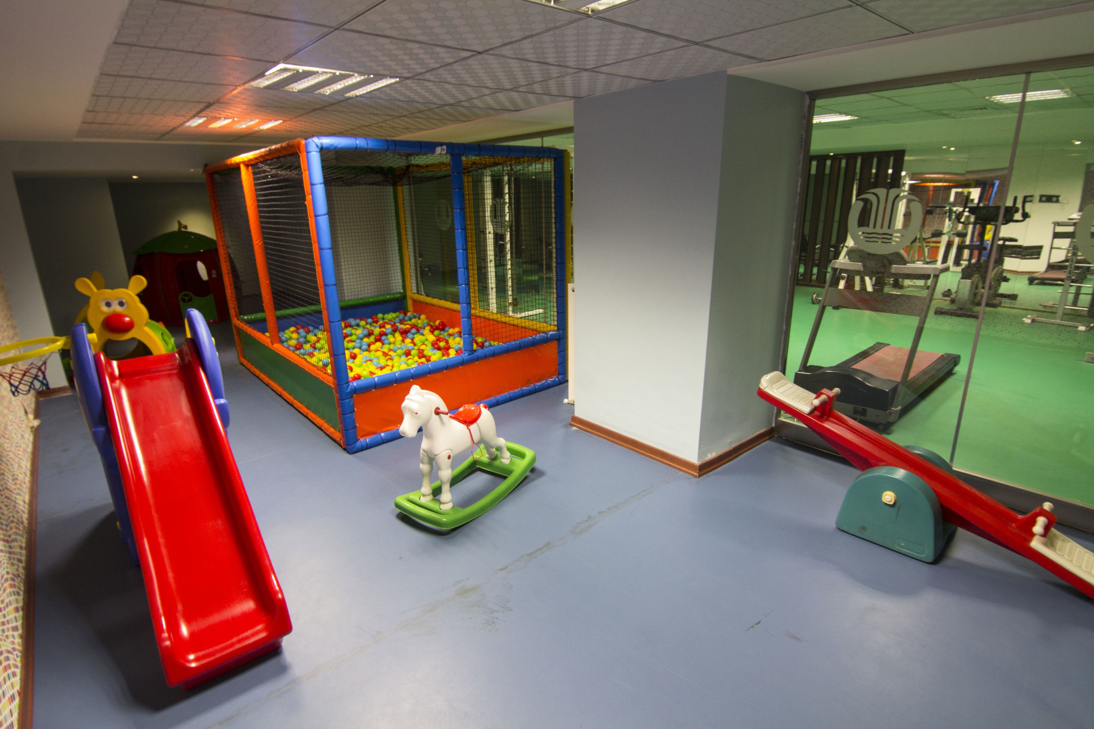 A play area with a ball pit, slides, and a seesaw.