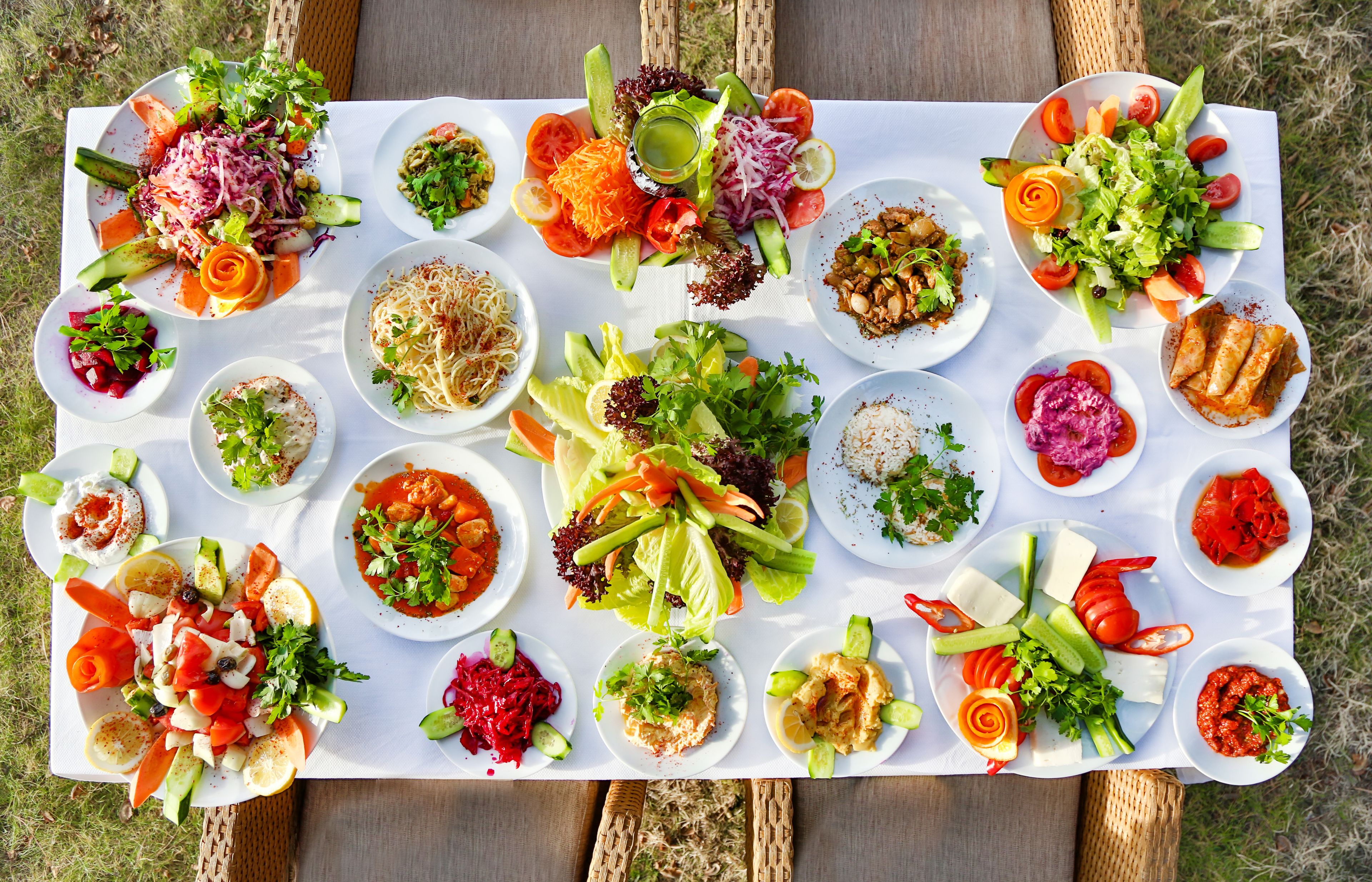 A variety of dishes arranged on a table outdoors.