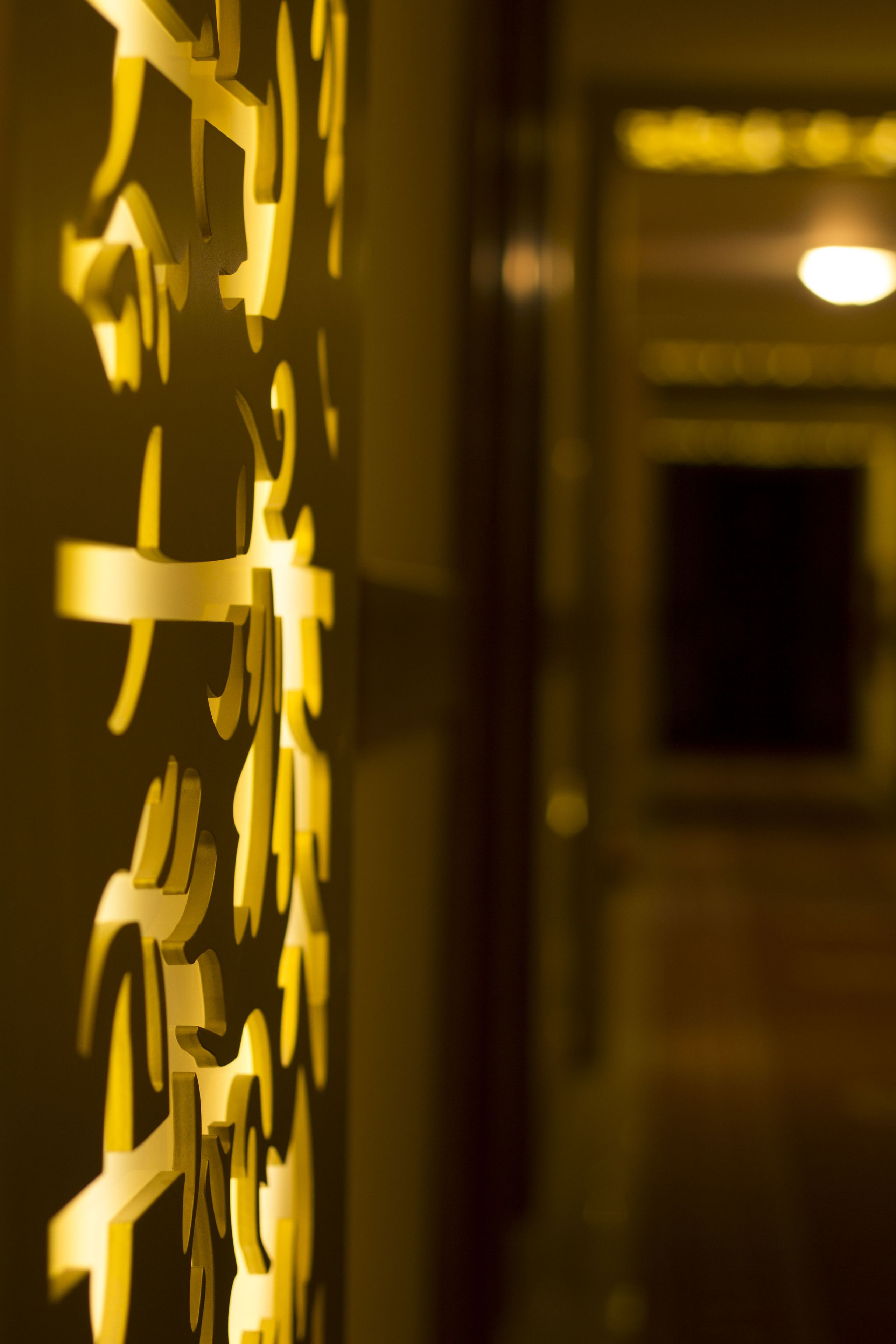 A close-up of a wall with abstract, illuminated cut-out shapes.