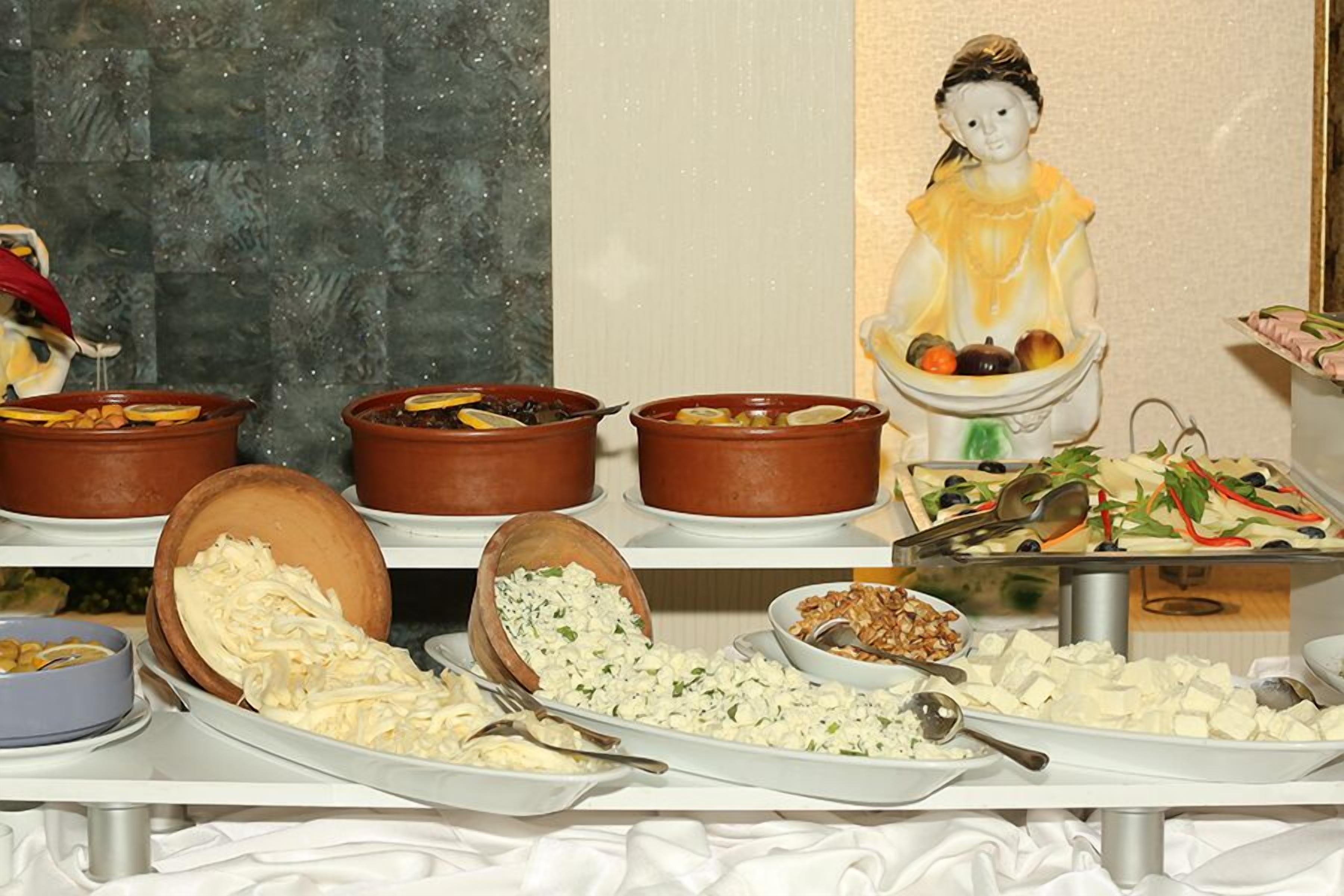 A buffet with various dishes and a decorative figure.