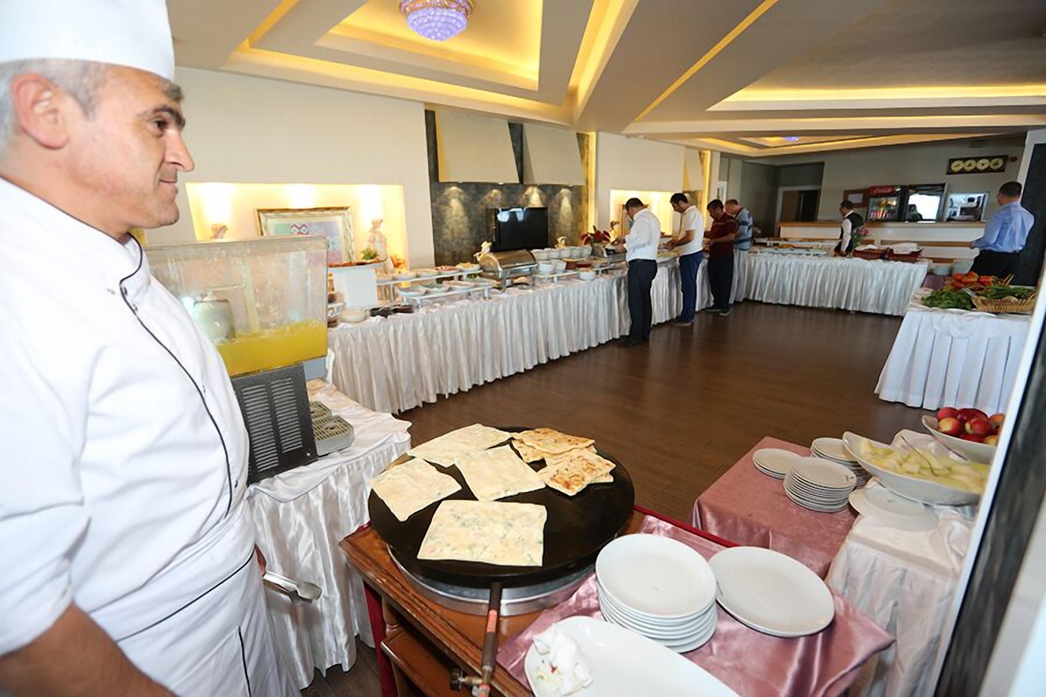 A buffet setup with multiple serving stations, a chef preparing food, and a variety of dishes displayed on tables.